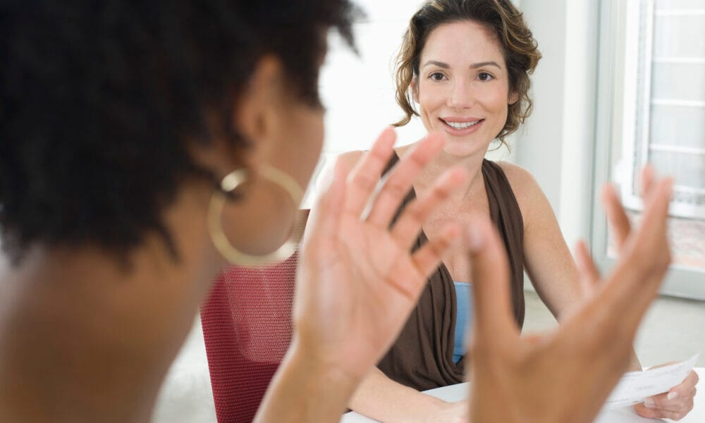 Two mid-adult office workers talking
